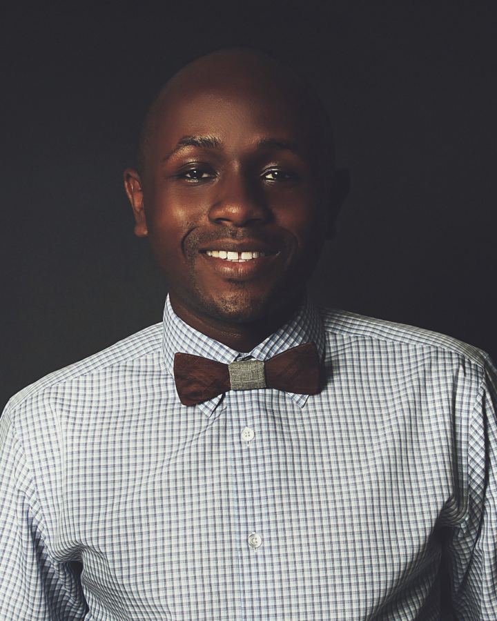 Ryan Perez smiling, wearing a checked shirt and a wooden bow tie